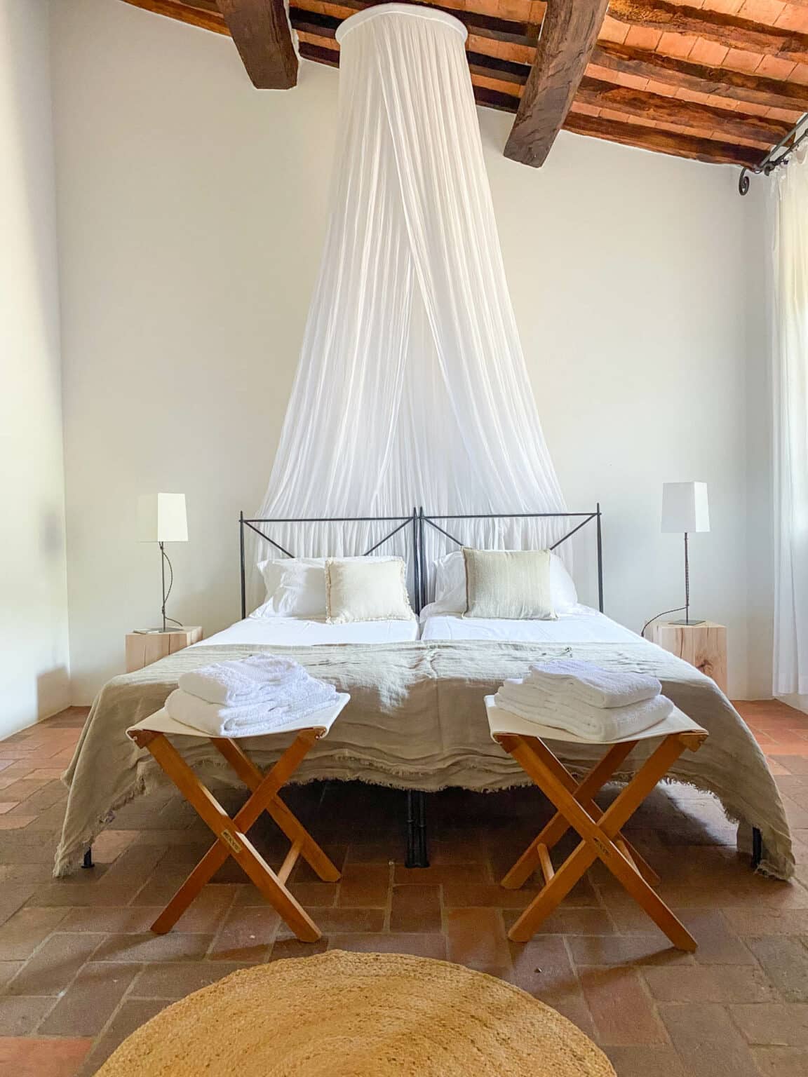 Einladendes Doppelbett mit natürlichen Stoffen im Zimmer Cosy im Abbadia Wine Relais, einem exklusiven Adults-only Hideaway in der Toskana.