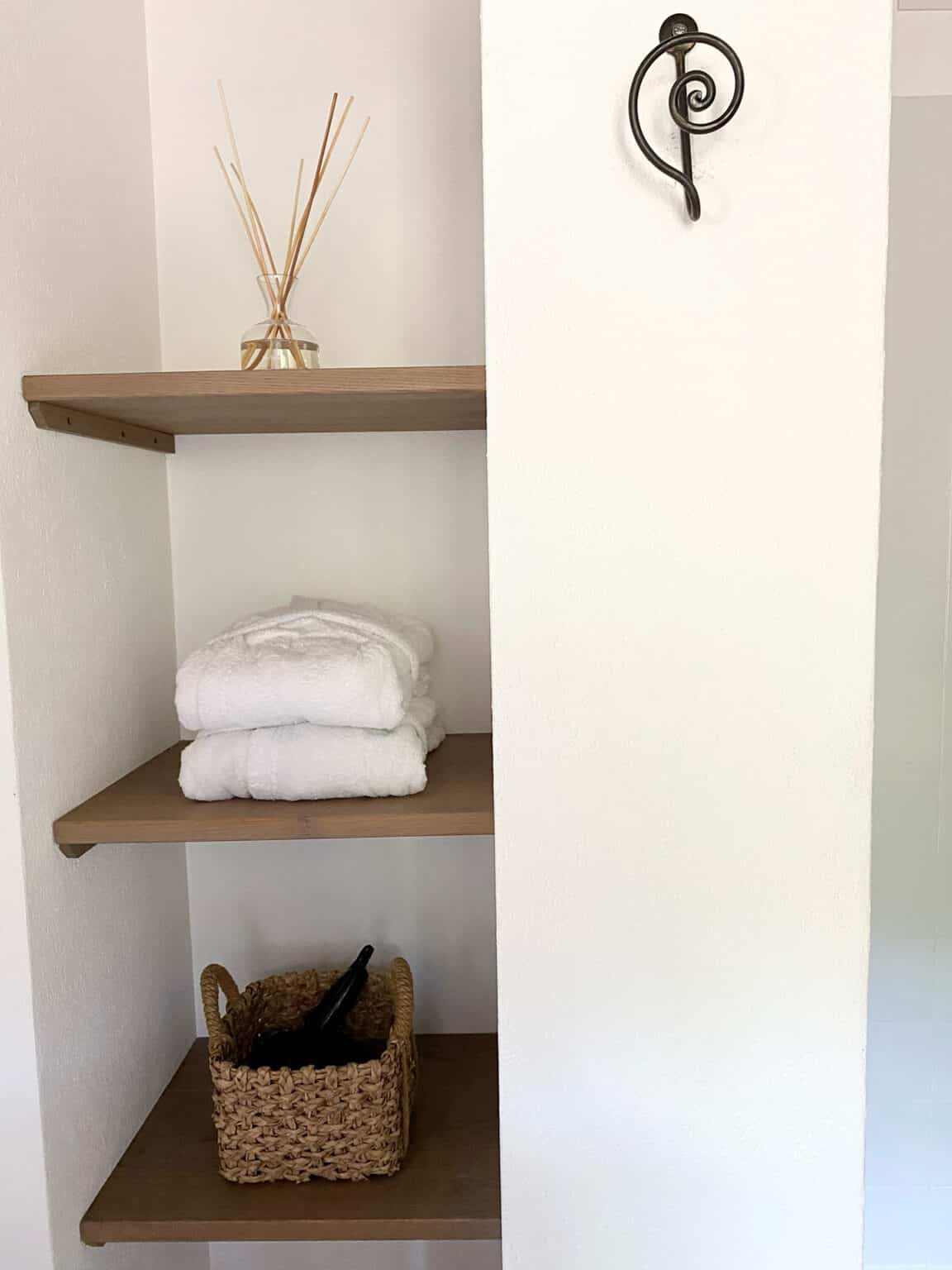 Integrierte Wandregale mit perfekt gefalteten weißen Handtüchern aus organischen Materialien im Zimmer Cosy.