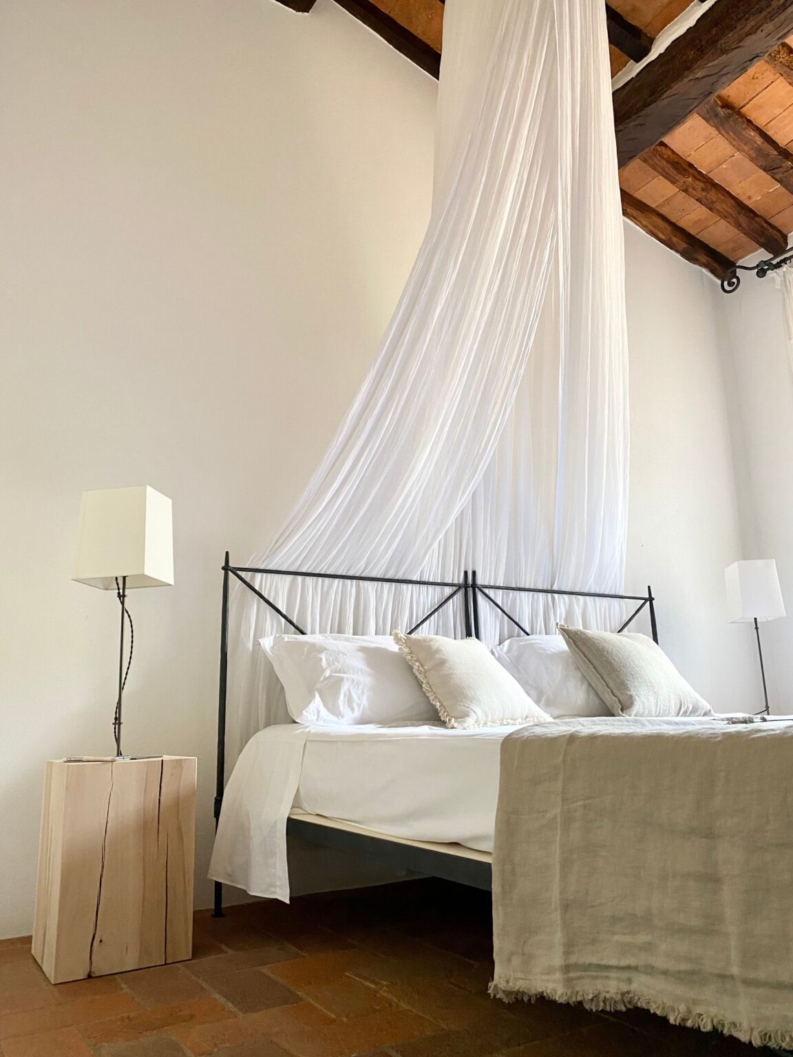 Elegantes Himmelbett mit weißer Bettwäsche in einem hellen Hotelzimmer, gestaltet im zeitlosen Silent-Luxury-Design.
